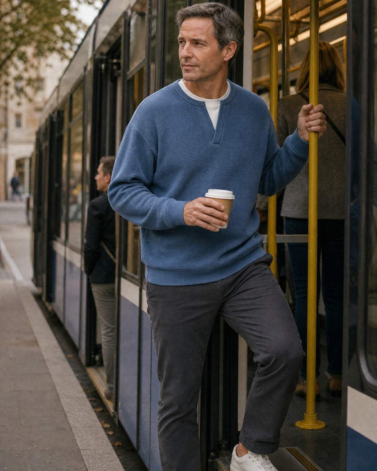 Denholm waffle-knit top in Blue, stepping onto a tram
