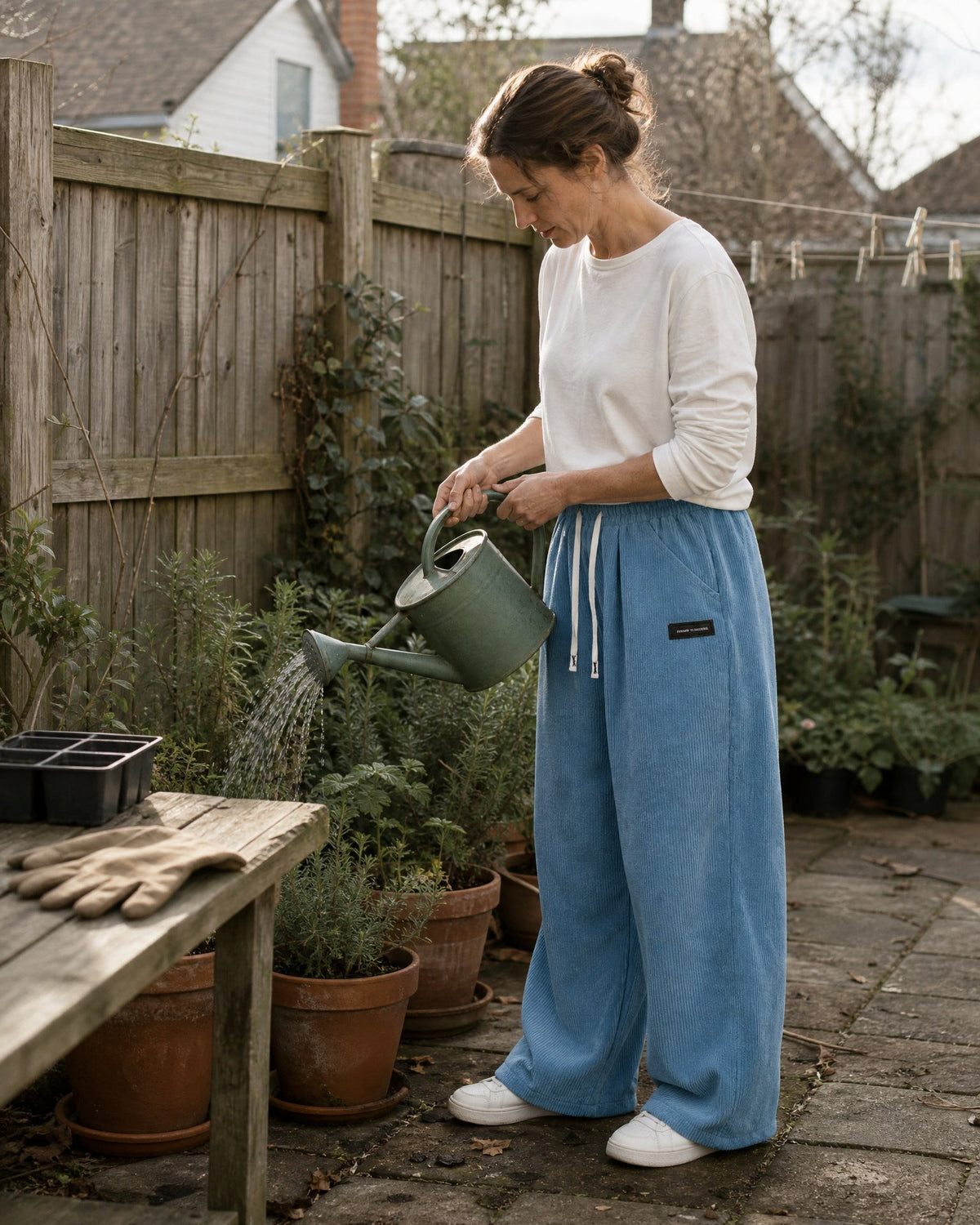 Tilbury wide-leg corduroy pants in Blue, watering plants in the garden